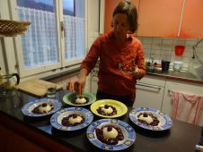 Blick vom Esszimmer in die Küche mit dekorierender Köchin